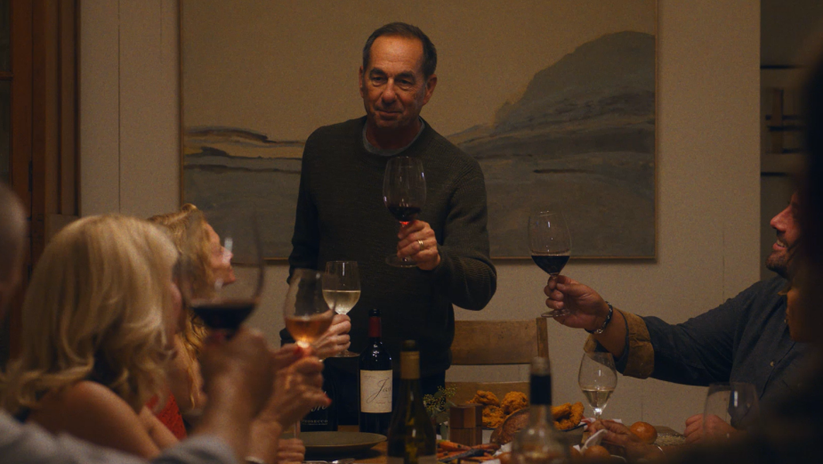 man standing in front of a table holding a wine glass