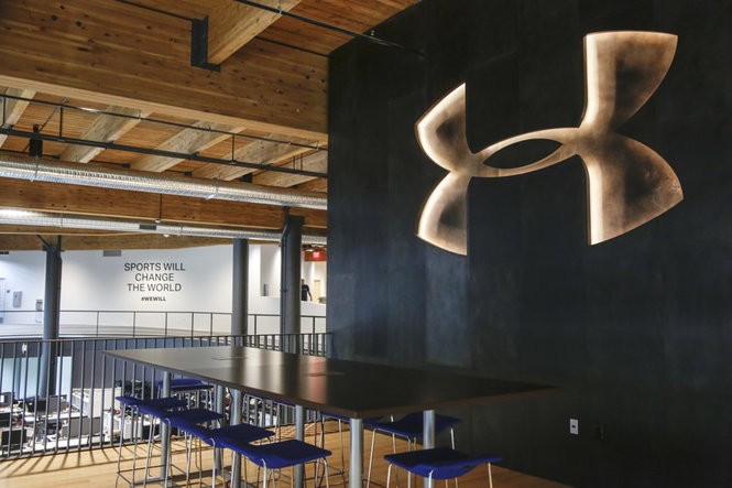inside a building with a table adn charis adn the Under Armour logo on the wall