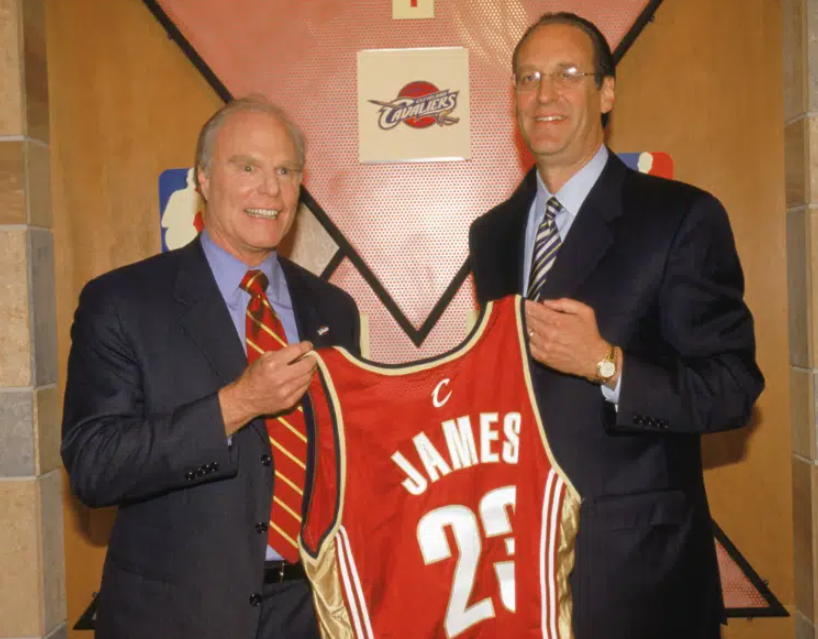two white men holding a basketball jersey with the name James and number 23
