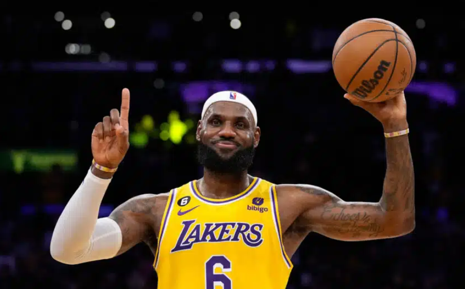man in a yellow Lakers jersy holding a basketball