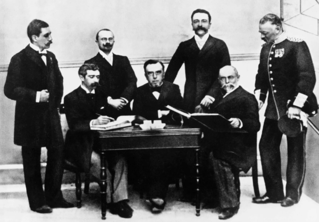 group of men standing and sitting at a table