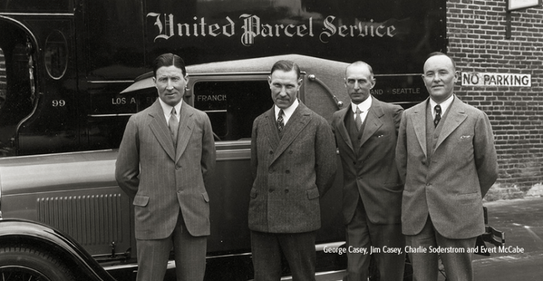 Vintage black and white photo of three men standing in front of a car